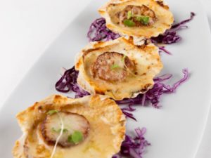 Scallops in their shells with creamy sauce in Fine Dining Style
